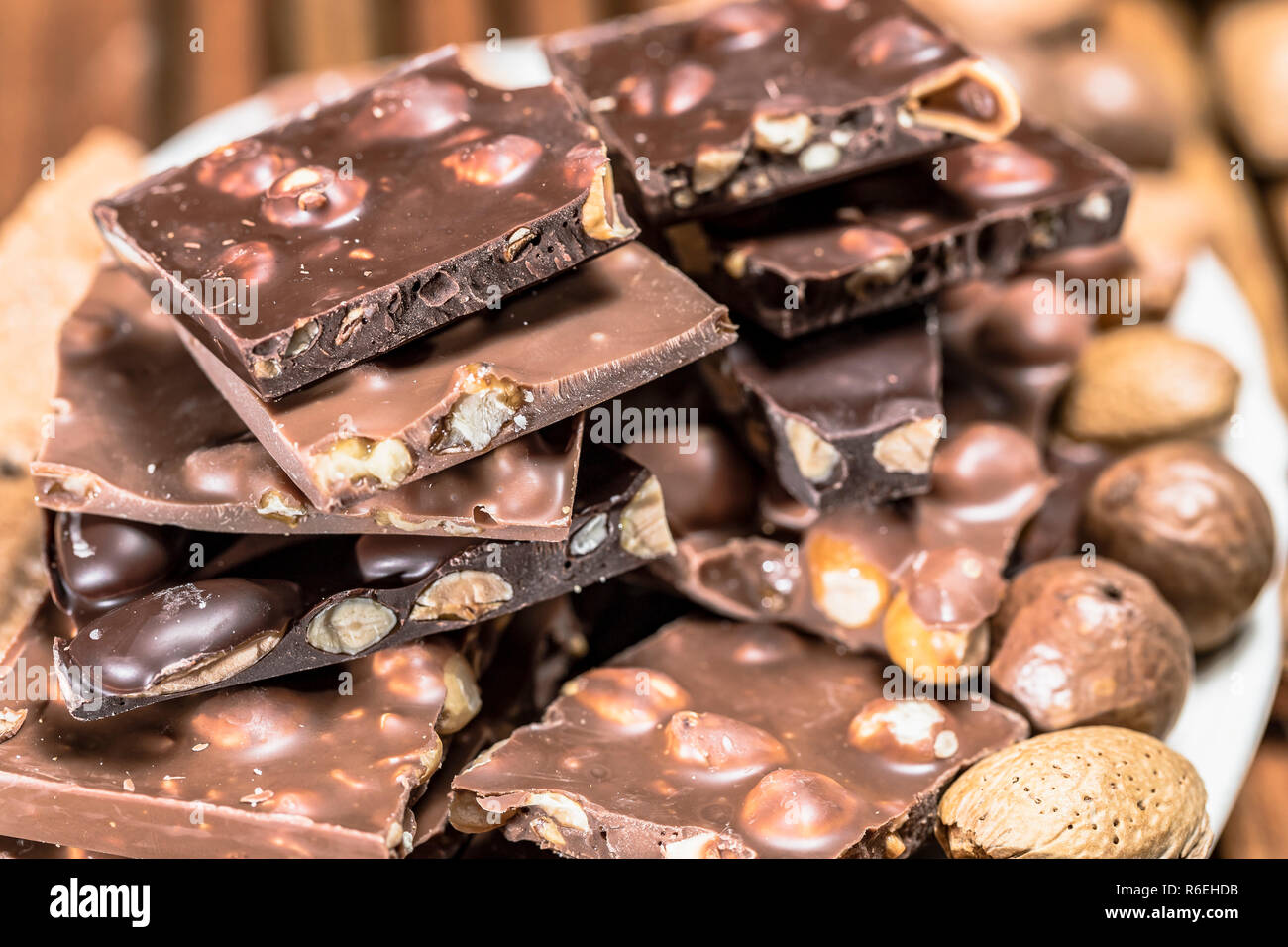 Platte von Mutter Schokolade mit ganzen Haselnüssen - Nahaufnahme Stockfoto