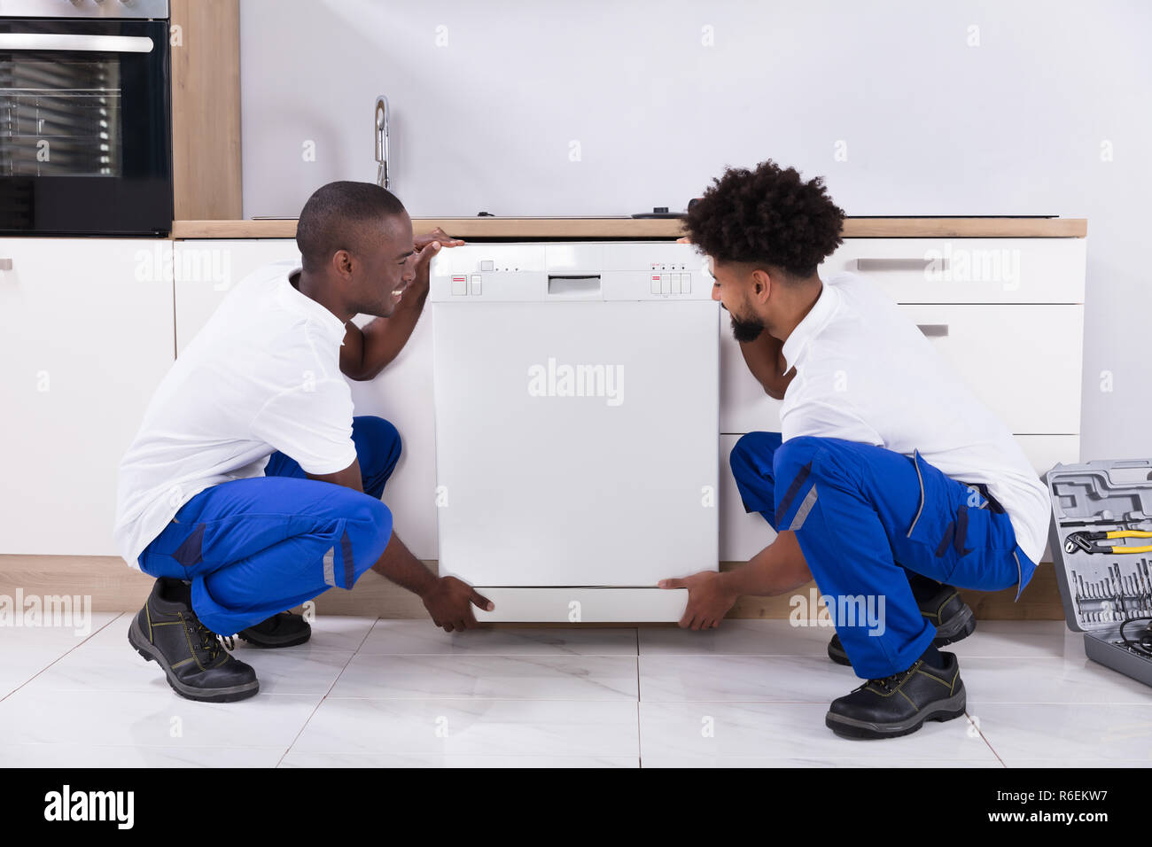 Zwei praktische Männer zur Festsetzung der Geschirrspüler in der Küche Stockfoto
