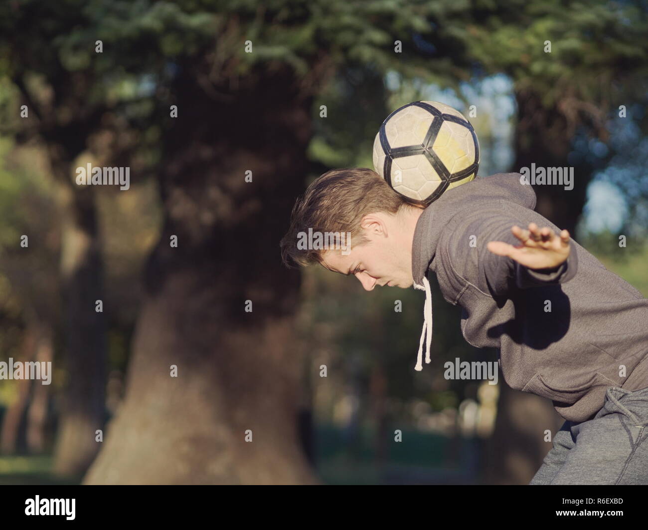 Fußball-Spieler Balancing Fußball im Park an einem sonnigen Herbsttag Stockfoto