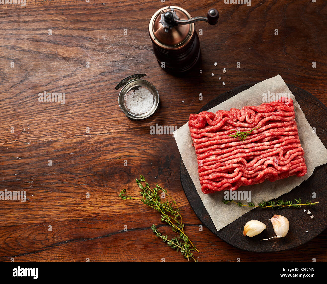 Hackfleisch Fleisch mit Salz, Knoblauch, Kräutern auf Holztisch. Ansicht von oben. Stockfoto