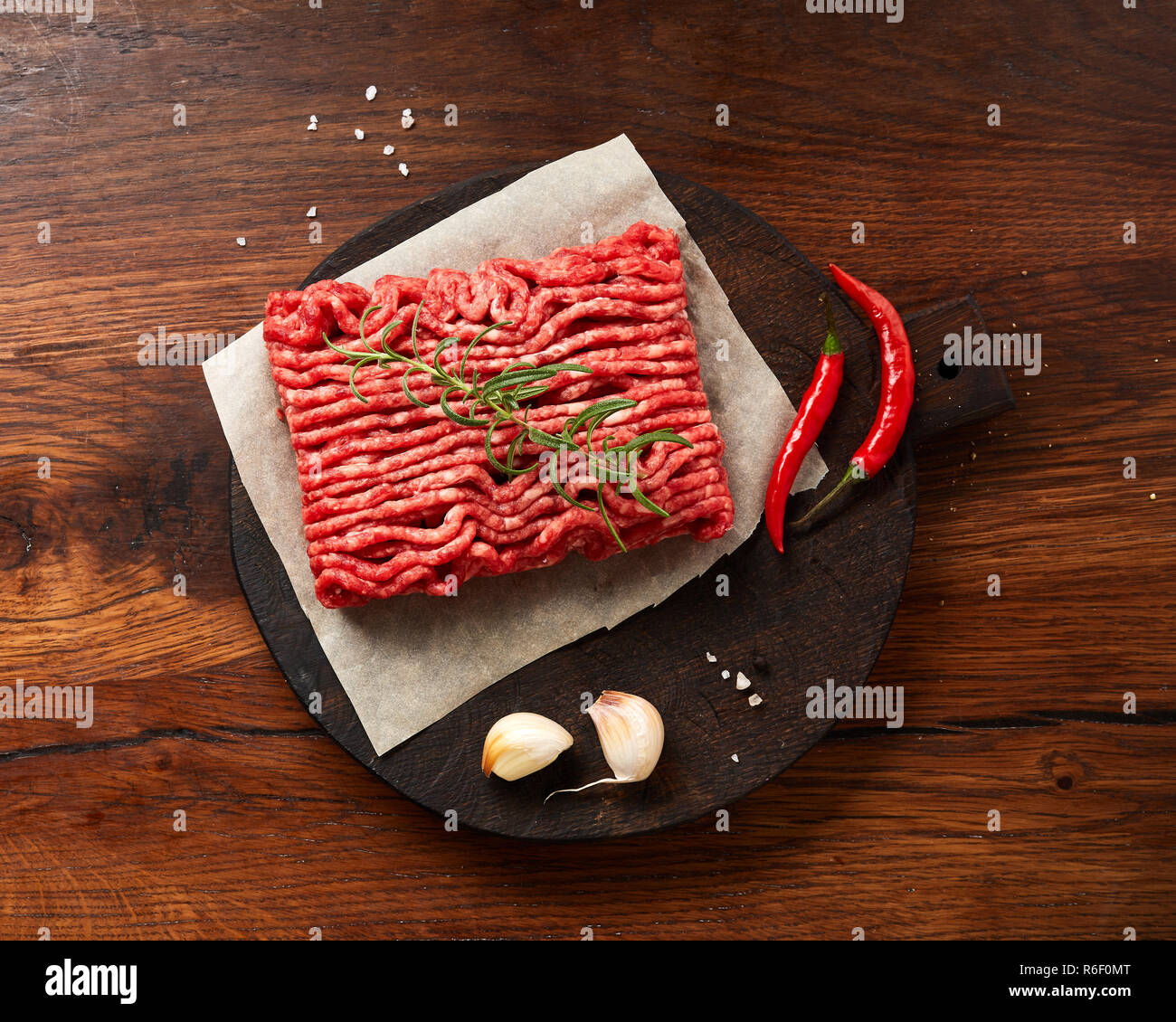 Hackfleisch Fleisch mit Salz, Knoblauch, Kräutern auf Holztisch. Ansicht von oben. Stockfoto