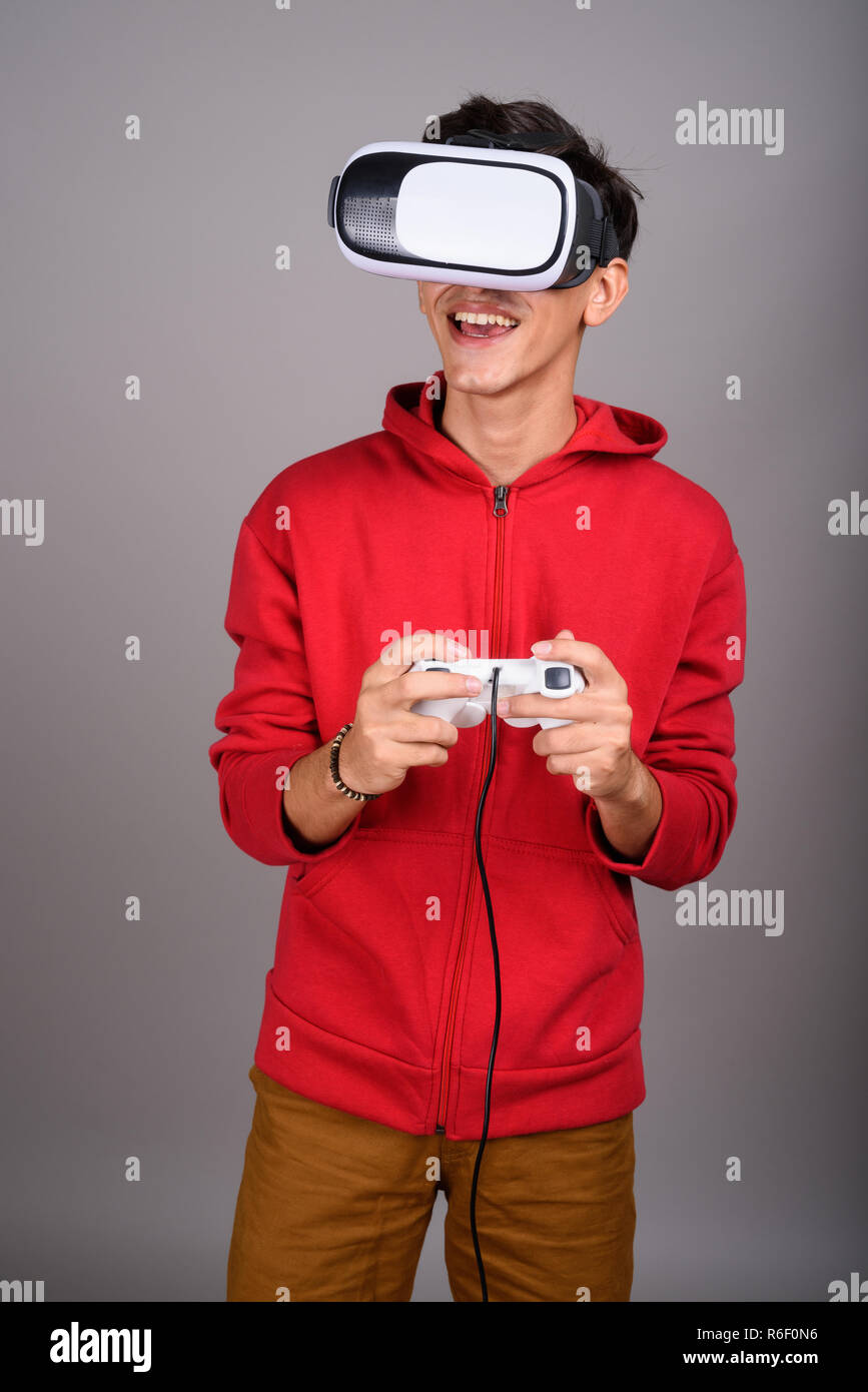 Persische Teenager mit VR-Brille und Game Controller für die virtuelle Realität Stockfoto