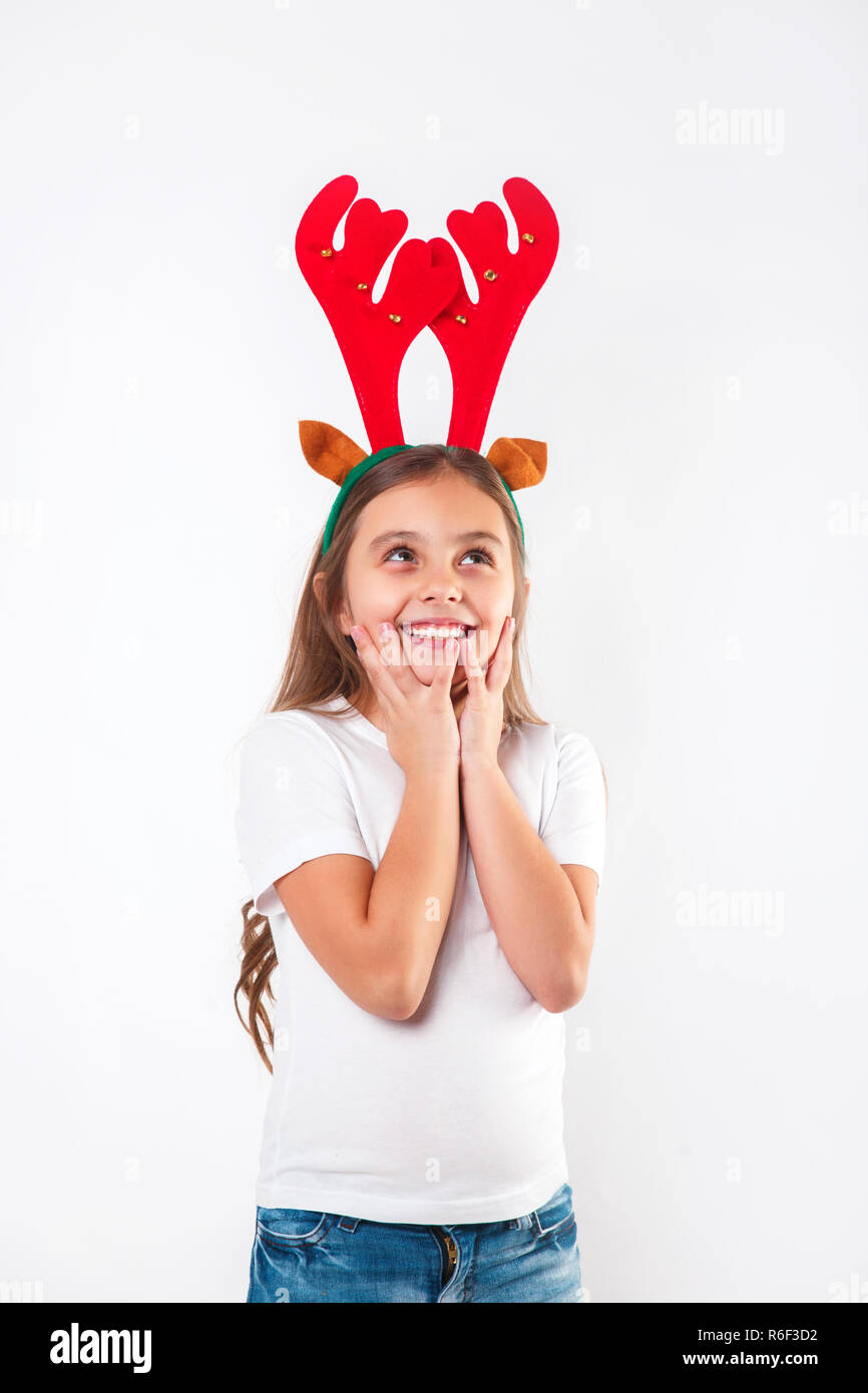 Lächelnd lustig Kind in deer Hörner und weißes T-Shirt oben zu schauen. Stockfoto