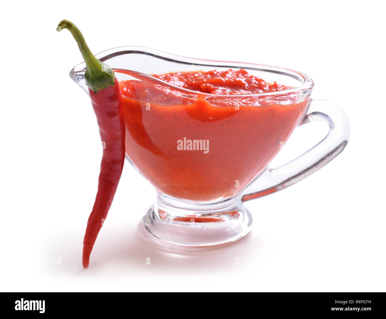 Red Chili Sauce in der Soße Boot. Mit Pfeffer. Auf weissem Hintergrund. Stockfoto