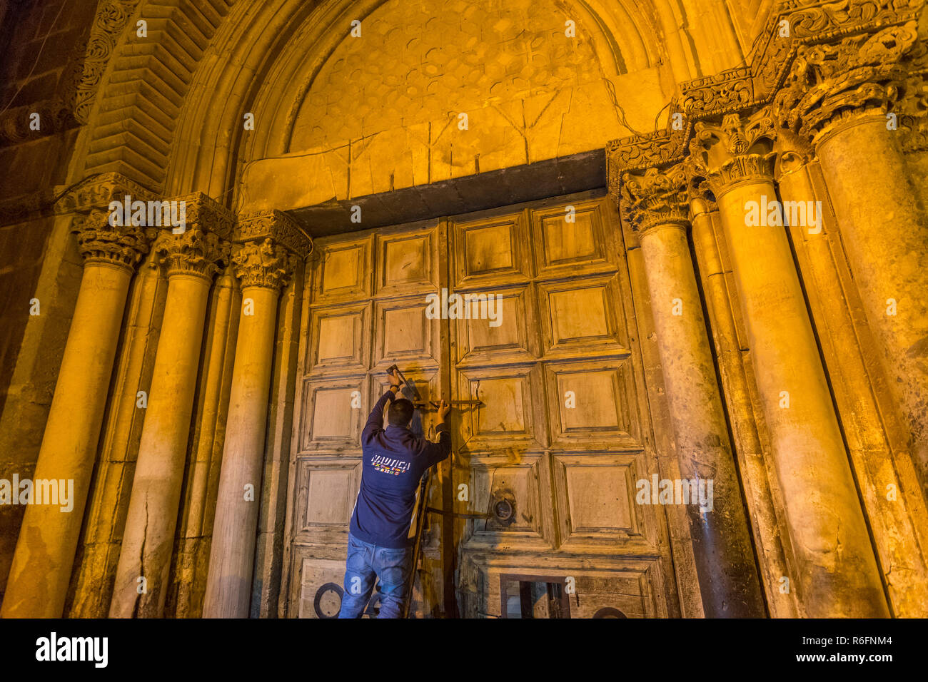 Ein Ritual der schließende Türen der Kirche des Heiligen Grabes muslimischen Schlüsselhalter verriegelt die Türen während der Griechisch-orthodoxen Mönch wartet eine Leiter Jeru übergeben werden Stockfoto