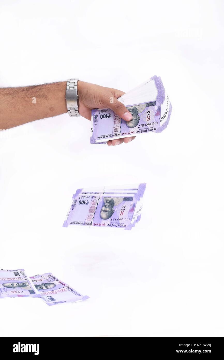 Bild von Hand wirft neue indische Währung. Auf den weißen Hintergrund isoliert. Stockfoto