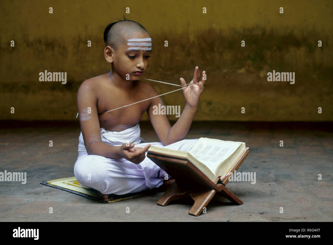 hinduistischer Junge trägt heiligen Faden und liest alten Text, indien, asien Stockfoto