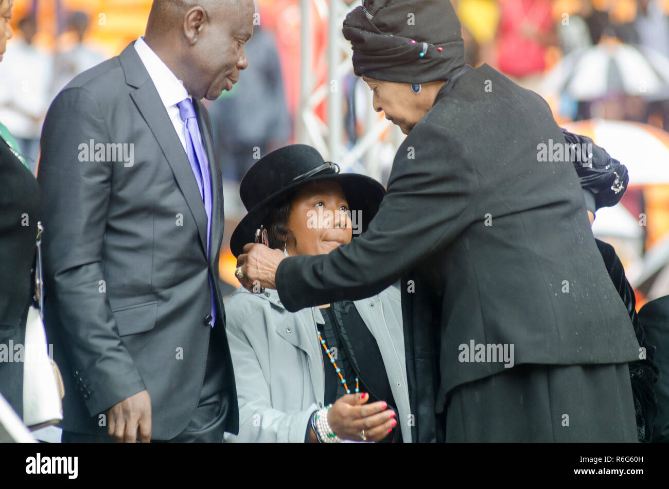Umarmt Winnie Mandela Nelson Mandela's Tochter Maki (Makiziwe) Mandela, als sie die öffentliche Trauerfeier für ehemaligen Präsidenten Nelson Mandela (Madiba) am FNB-Stadion, in Soweto, Südafrika, Dienstag, 10 Dezember, 2013 eintrifft. Makiziwe ist die Tochter von Madiba's erste Frau Evelyn Mase. Foto: EVA-LOTTA JANSSON Stockfoto