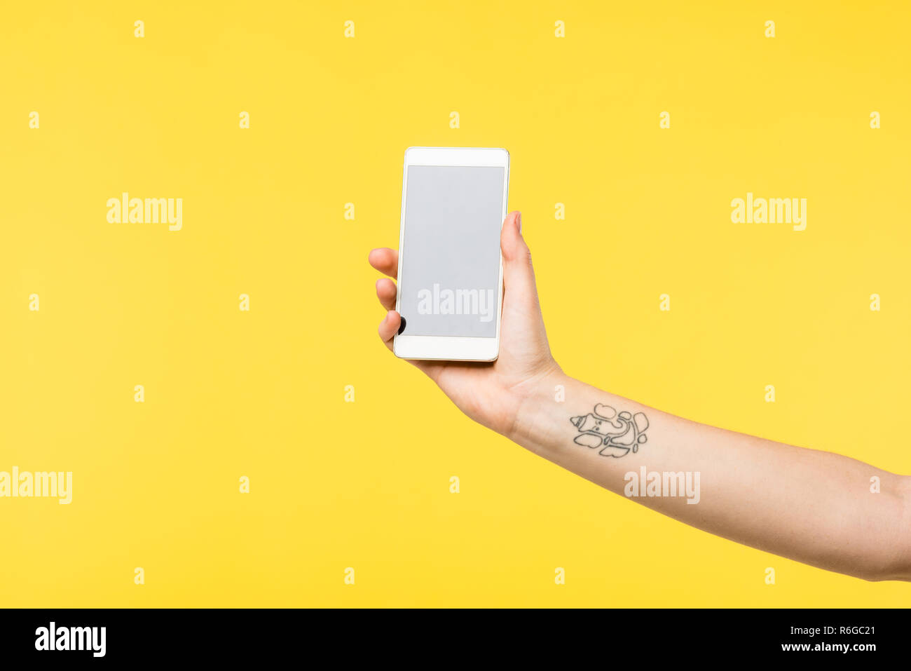 7/8 Schuß von Mädchen, dass Smartphone mit leerer Bildschirm isoliert auf Gelb Stockfoto