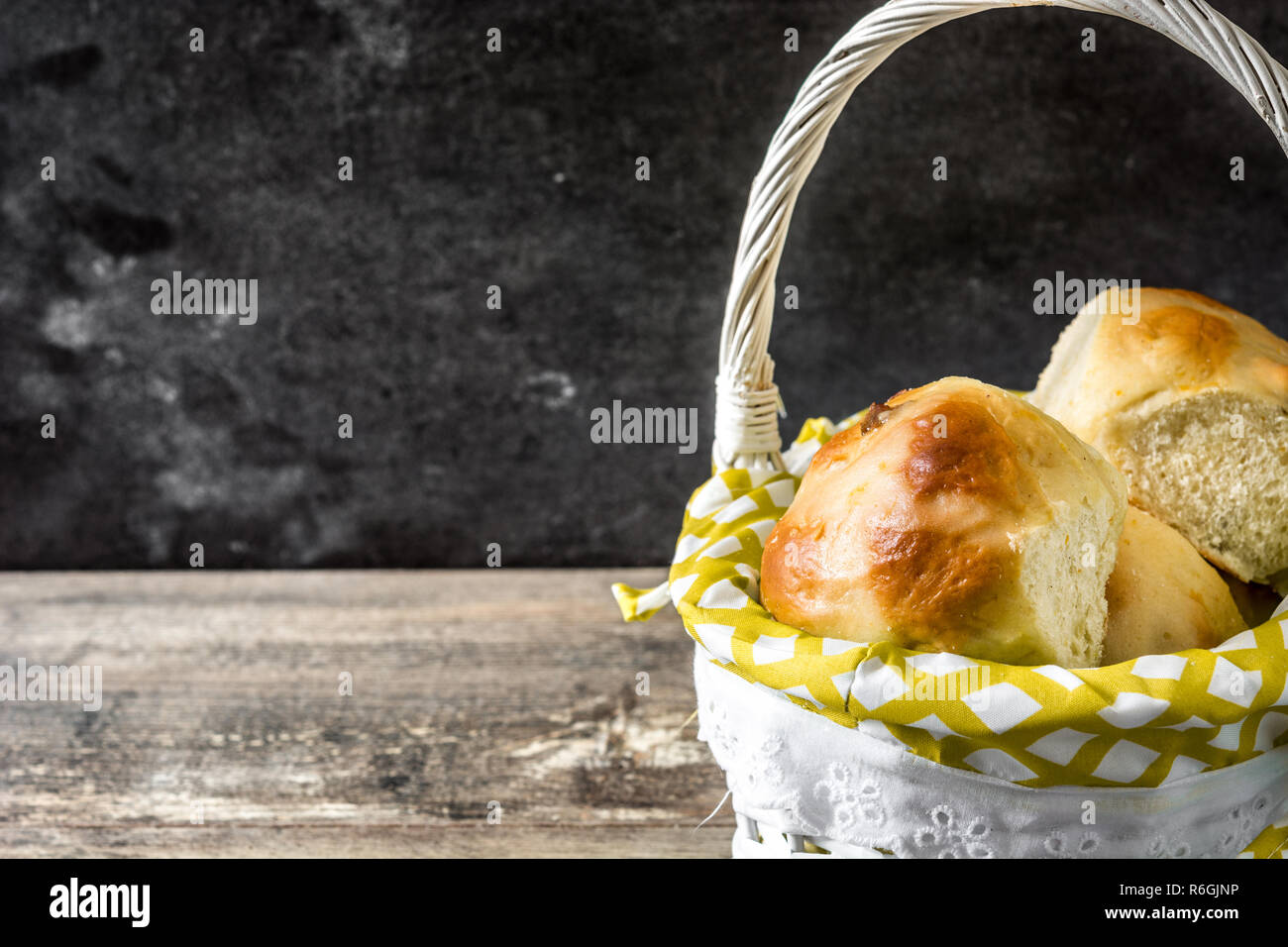 Schöne traditionelle Ostern Hot Cross Buns in einem Korb auf hölzernen Tisch. Copyspace Stockfoto Schöne traditionelle Ostern Hot Cross Buns in einem Korb auf hölzernen Tisch. Copyspace Stockfoto