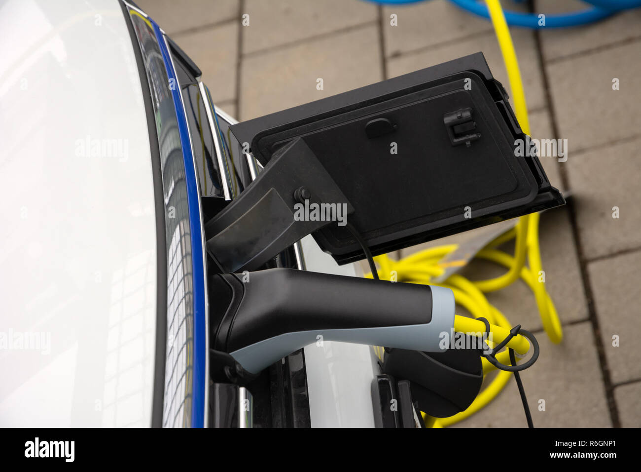 Aufladen von ein Elektroauto mit einem Stecker und Kabel Stockfoto