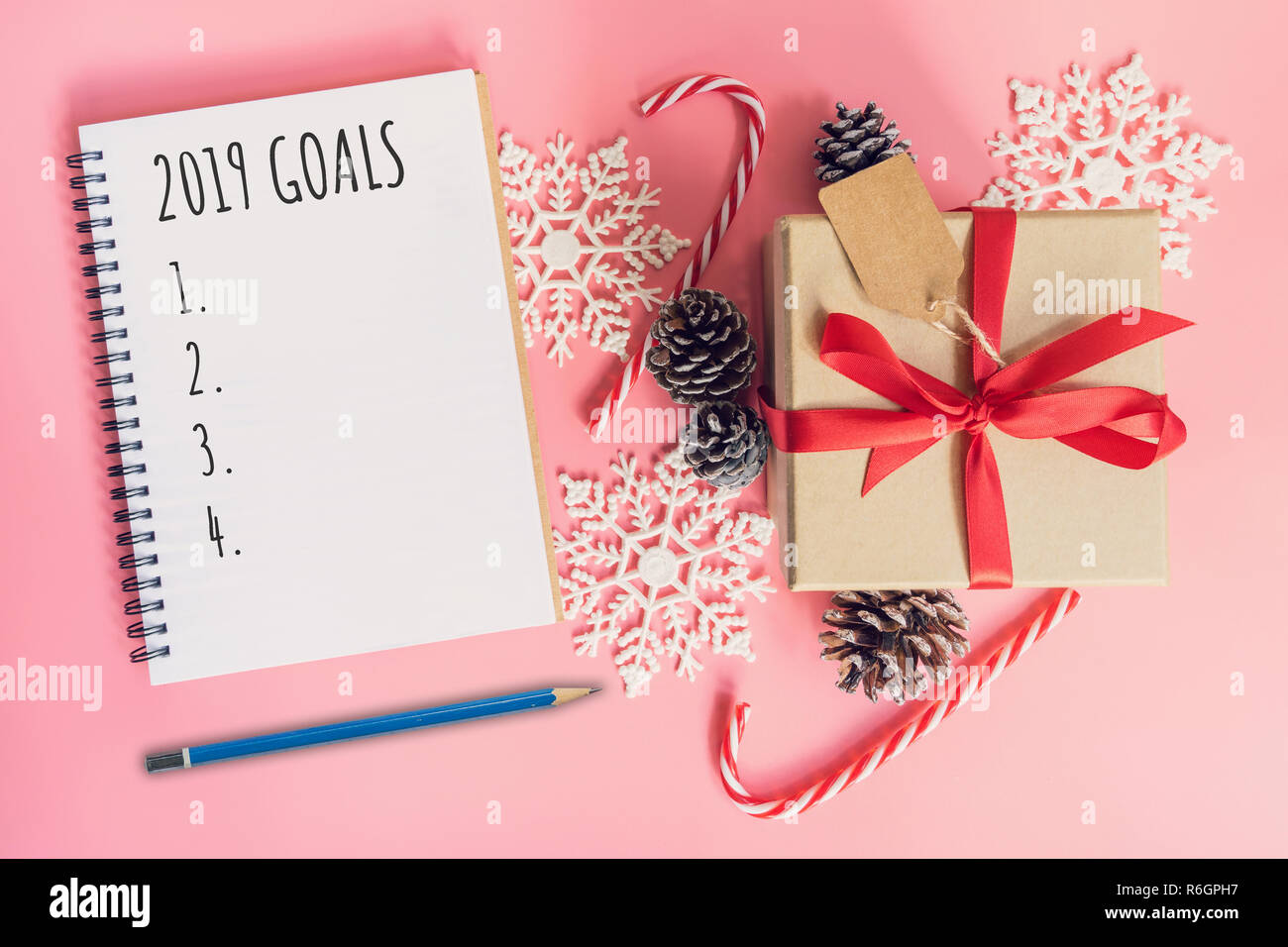 2019 Ziele, Ansicht von oben braun Geschenkbox, Notebook und Weihnachten Dekoration für das neue Jahr auf dem rosafarbenen Pastelltönen. Stockfoto