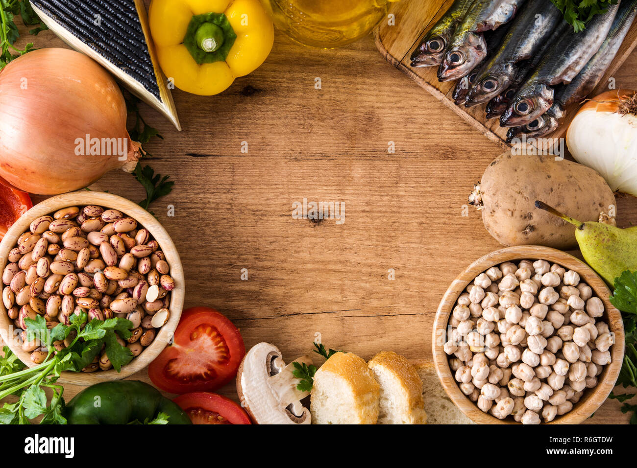 Das gesunde Essen. Mediterrane Ernährung. Obst, Gemüse, Getreide, Nüsse Olivenöl und Fisch auf Holztisch. Ansicht von oben. Copyspace Stockfoto