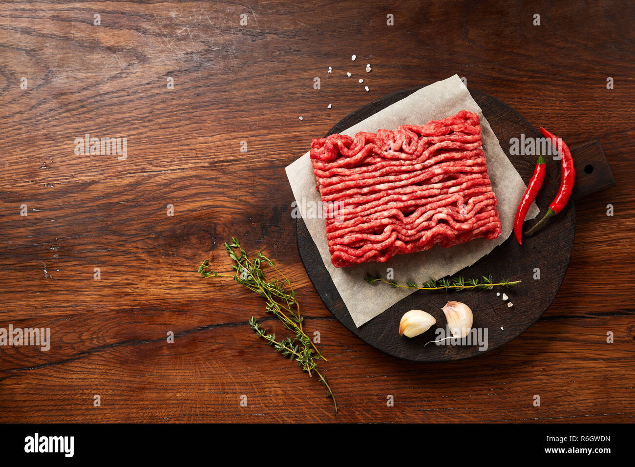 Hackfleisch Fleisch mit Salz, Knoblauch, Kräutern auf Holztisch. Ansicht von oben. Stockfoto