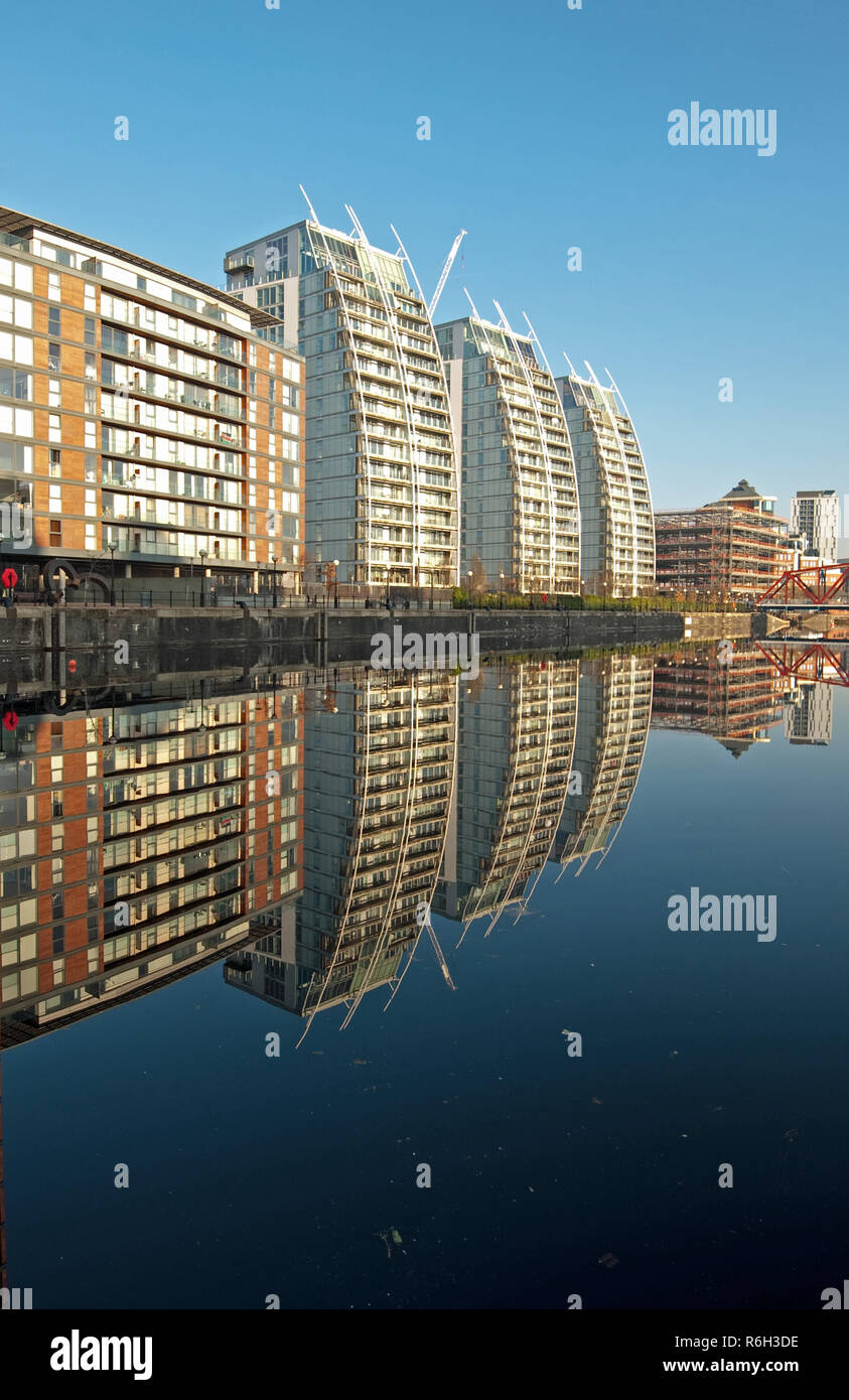 Symmetrie entlang der Wasser bei Salford Quays in der Nähe von Manchester, England, als eine ruhige, sonnige Winter schafft Bedingungen für die in der Nähe von perfekte Reflexionen Stockfoto