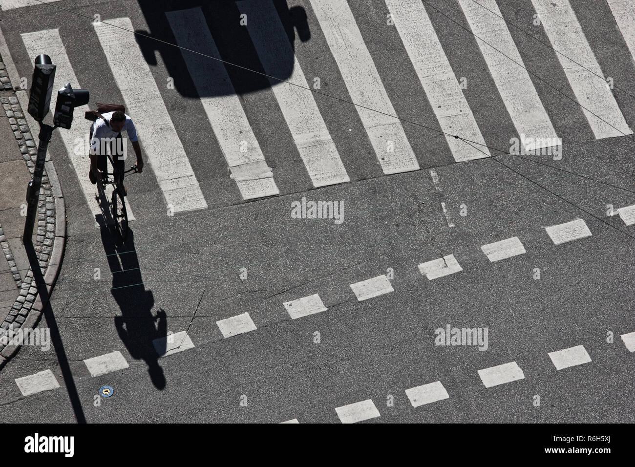 Hohe Aufnahme von Radfahrer und Schatten Form von Auto am Fußgängerüberweg, Kopenhagen, Dänemark, Skandinavien Stockfoto