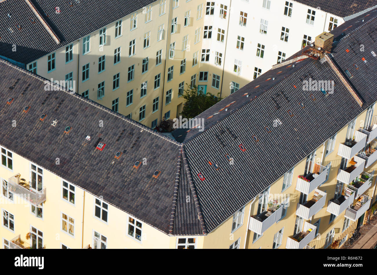 Gelb lackiert Mehrparteienhaus um den zentralen Innenhof mit Garten von oben, Christianshavn, Kopenhagen, Dänemark, Skandinavien Stockfoto