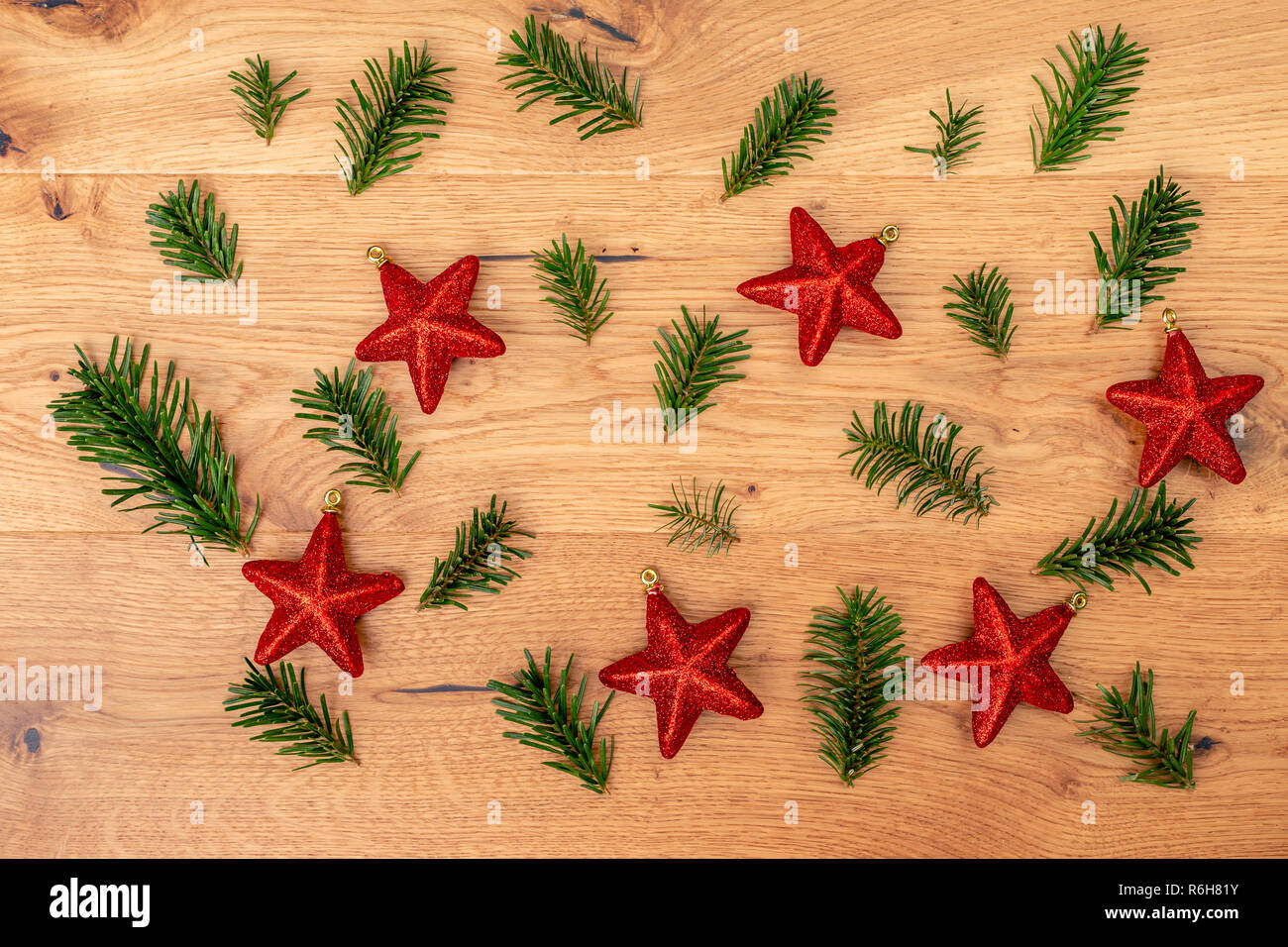 Weihnachten Hintergrund mit Tannenbaum, Rot glänzende Sterne auf braune Holztisch. Startseite flache Ansicht mit kopieren. Stockfoto