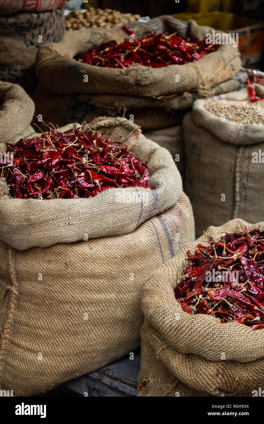 Getrocknete rote chilles auf Anzeige in offenen überstieg hessische Säcke auf einem öffentlichen Markt in Indien. Stockfoto