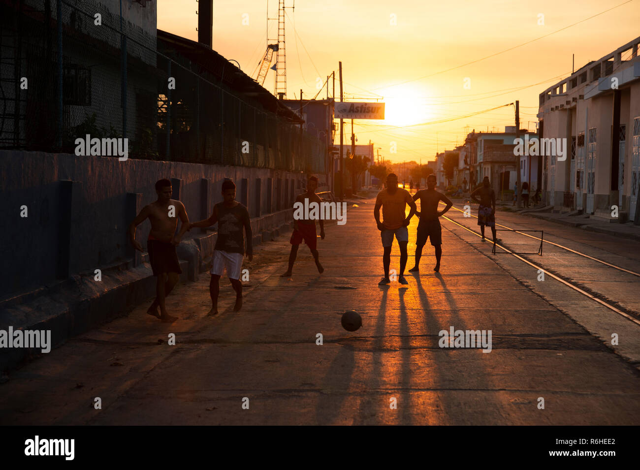 Silhouetten der kubanischen Jungen spielen Straßenfußball, wie die Sonne hinter Ihnen in Cienfuegos Kuba Stockfoto