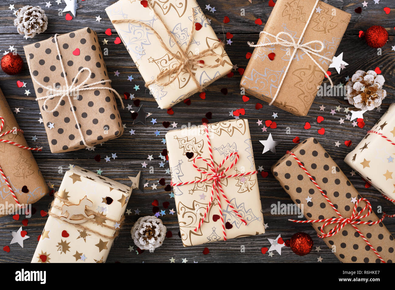 Weihnachten Geschenk Boxen & Pinienzapfen auf dekoriert festlich gedeckten Tisch mit funkeln Sterne. Eingepackte Geschenke und Bänder Garn. Winterurlaub. Stockfoto