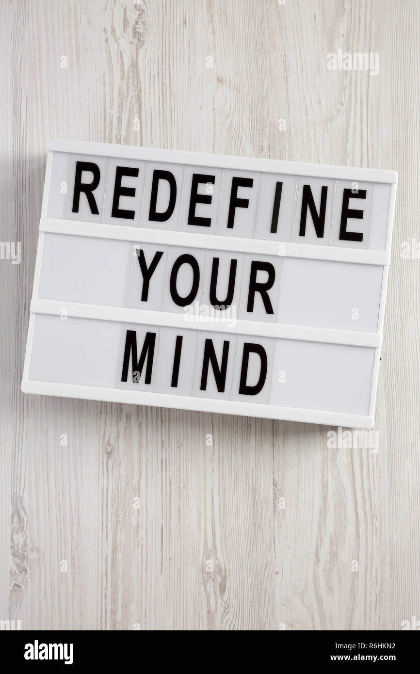 ' Wörter definieren Sie Ihren Verstand" auf Lightbox über weiß Holz- Oberfläche, Ansicht von oben. Overhead, flach, von oben. Stockfoto