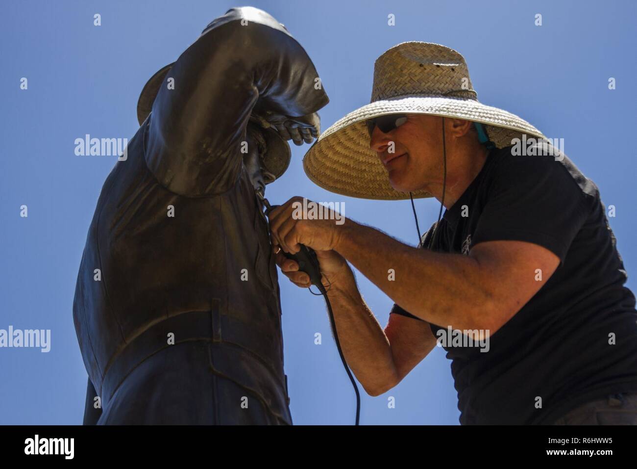 Herr Barry Feinman über ein rotierendes Werkzeug zu einzelnen Spots werden Reinigung eine Bronzestatue der Marine während einem ehrenamtlichen Projekt im Park Semper Fi in San Clemente, Kalifornien, 19. Mai 2017. Marines arbeitete mit der Gemeinde in dem Bemühen, die Menschen in der Gegend von San Clemente zurückzugeben. Der Park widmet sich der Marines und Marine Familien auf diejenigen ehren, die in Zeiten des Krieges verloren gegangen sind. Stockfoto
