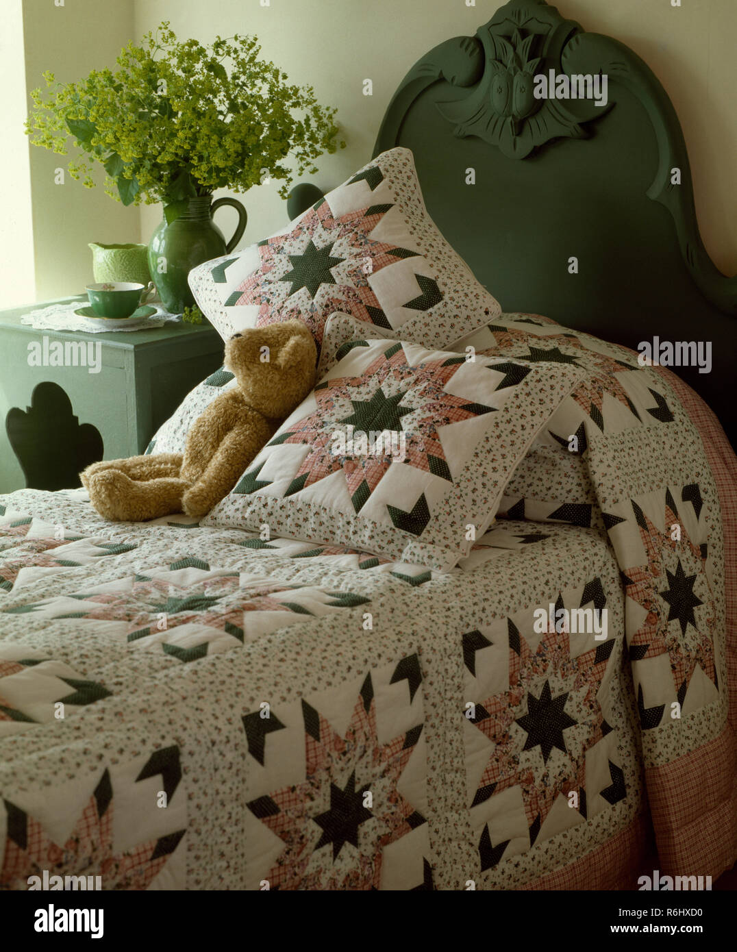 Patchwork Quilt und Kissen auf dem Bett mit gemalten Kopf Board Stockfoto