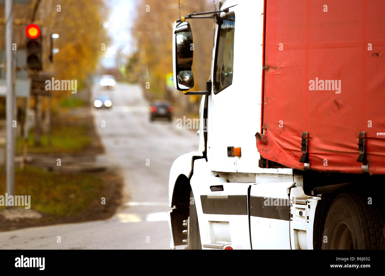 Der Motor van geht die Straße runter, an der Ampel rot brennt, weiße Kabine, rote Lkw Markise, alte van Markise, Rot ragged Markise für Lkw Stockfoto