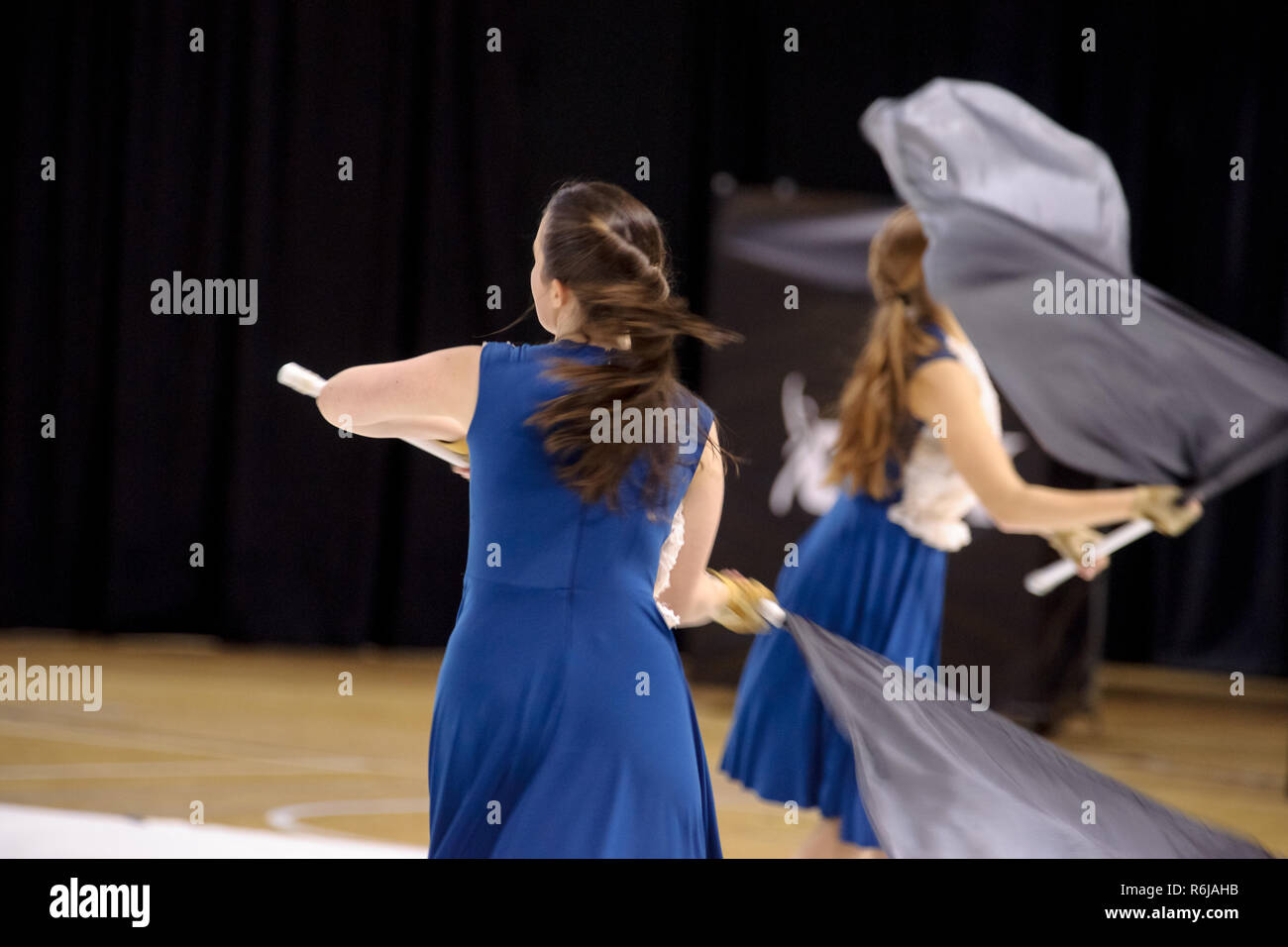 Farbe Schutz einer Drum & Bugle Corps während einer Indoor Contest mit flatternden Fahnen und tanzen Jugendliche Stockfoto