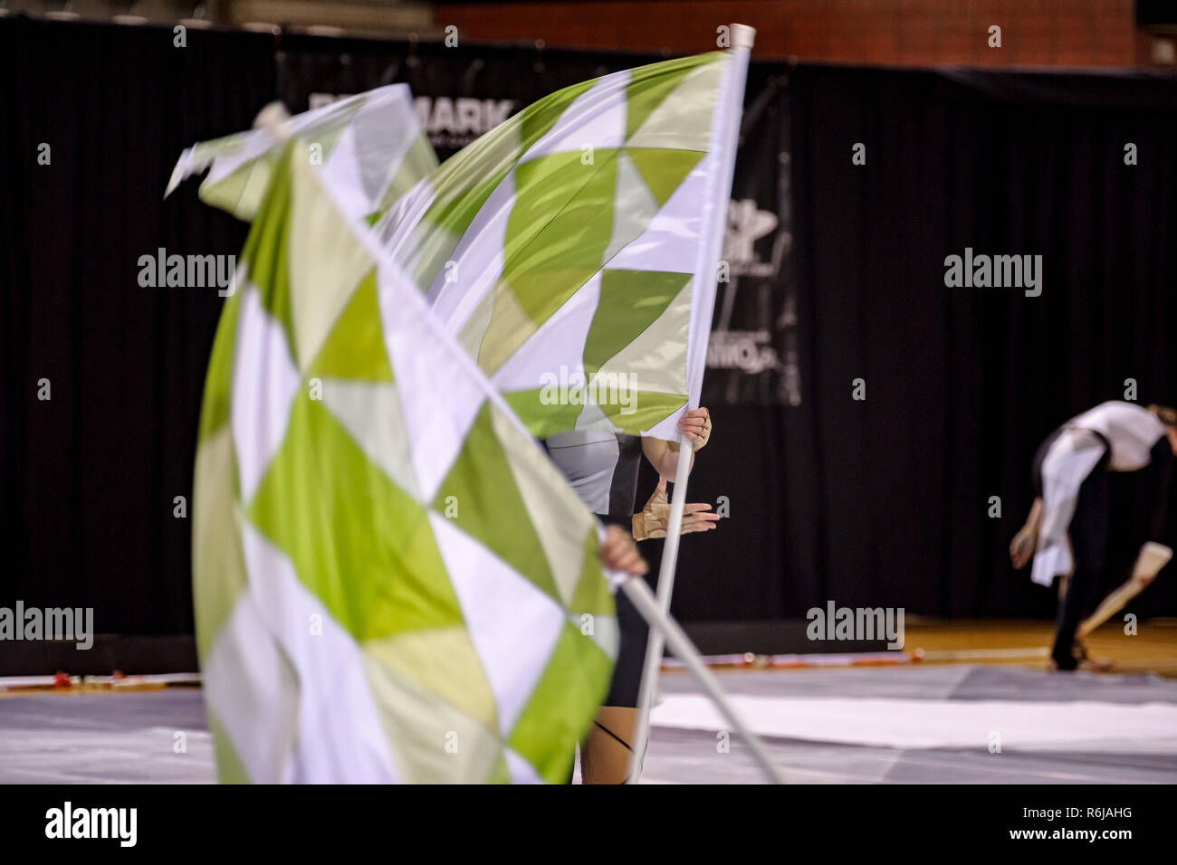 Farbe Schutz einer Drum & Bugle Corps während einer Indoor Contest mit flatternden Fahnen und tanzen Jugendliche Stockfoto