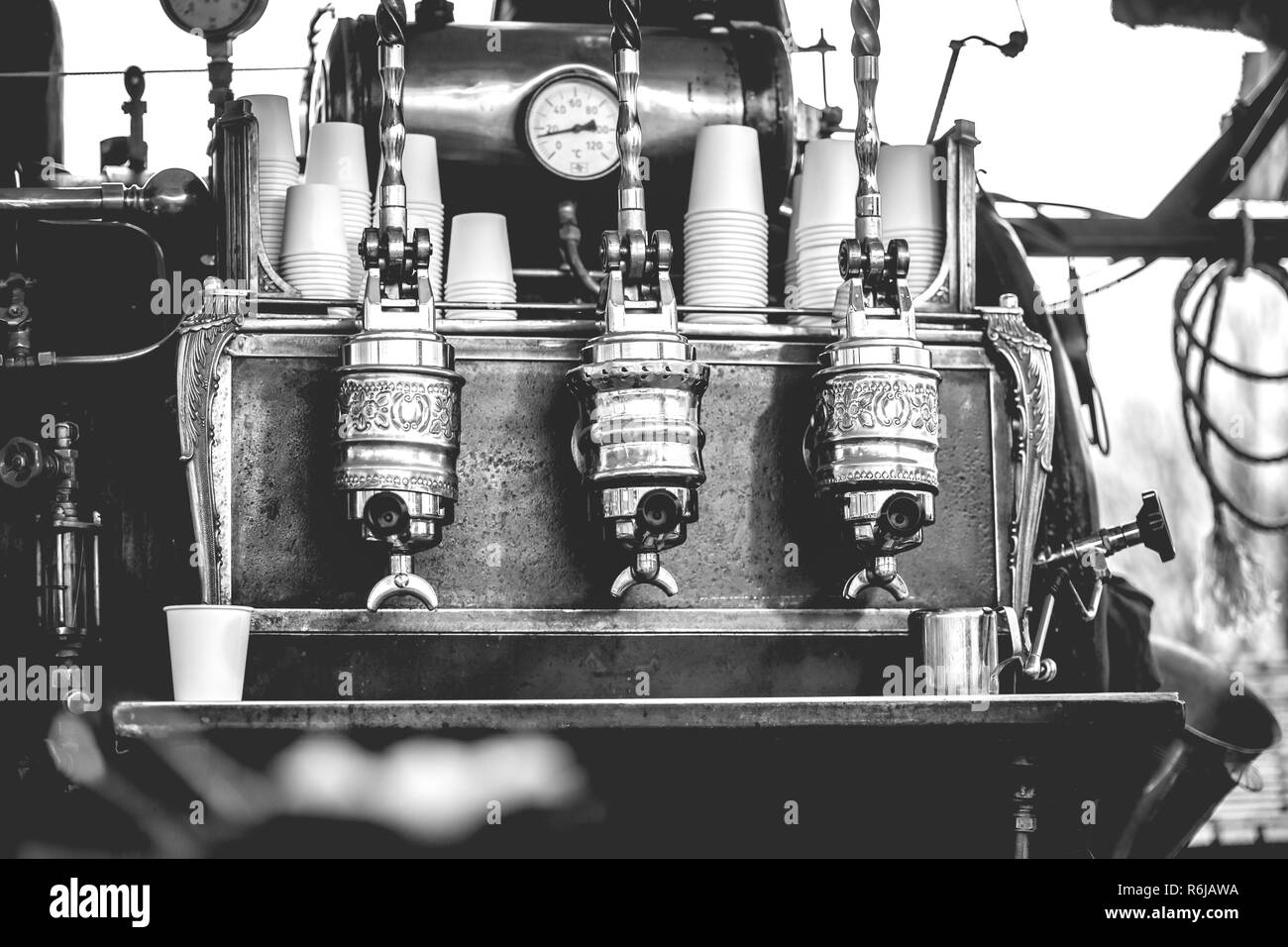 Vintage barista vorbereiten, um Kaffee zu Kunden im alten Stil Maschine mit handgefertigten Retro-look und throwback Kleidung in einen Marktstand Stockfoto