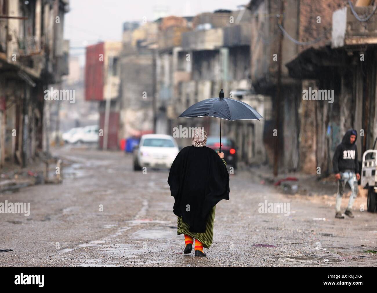 Mosul, Irak. 5 Dez, 2018. Eine Frau geht in die alte Stadt Mosul, Irak, Dez. 5, 2018. Rund 17 Monate nach der Befreiung von der extremistischen islamischen Staat (IST), militante Gruppe, Iraks zweitgrößte Stadt Mosul noch liegt in Trümmern und die Bewohner sind noch kämpfen, ihr Leben wieder aufzubauen. Quelle: Khalil Dawood/Xinhua/Alamy leben Nachrichten Stockfoto