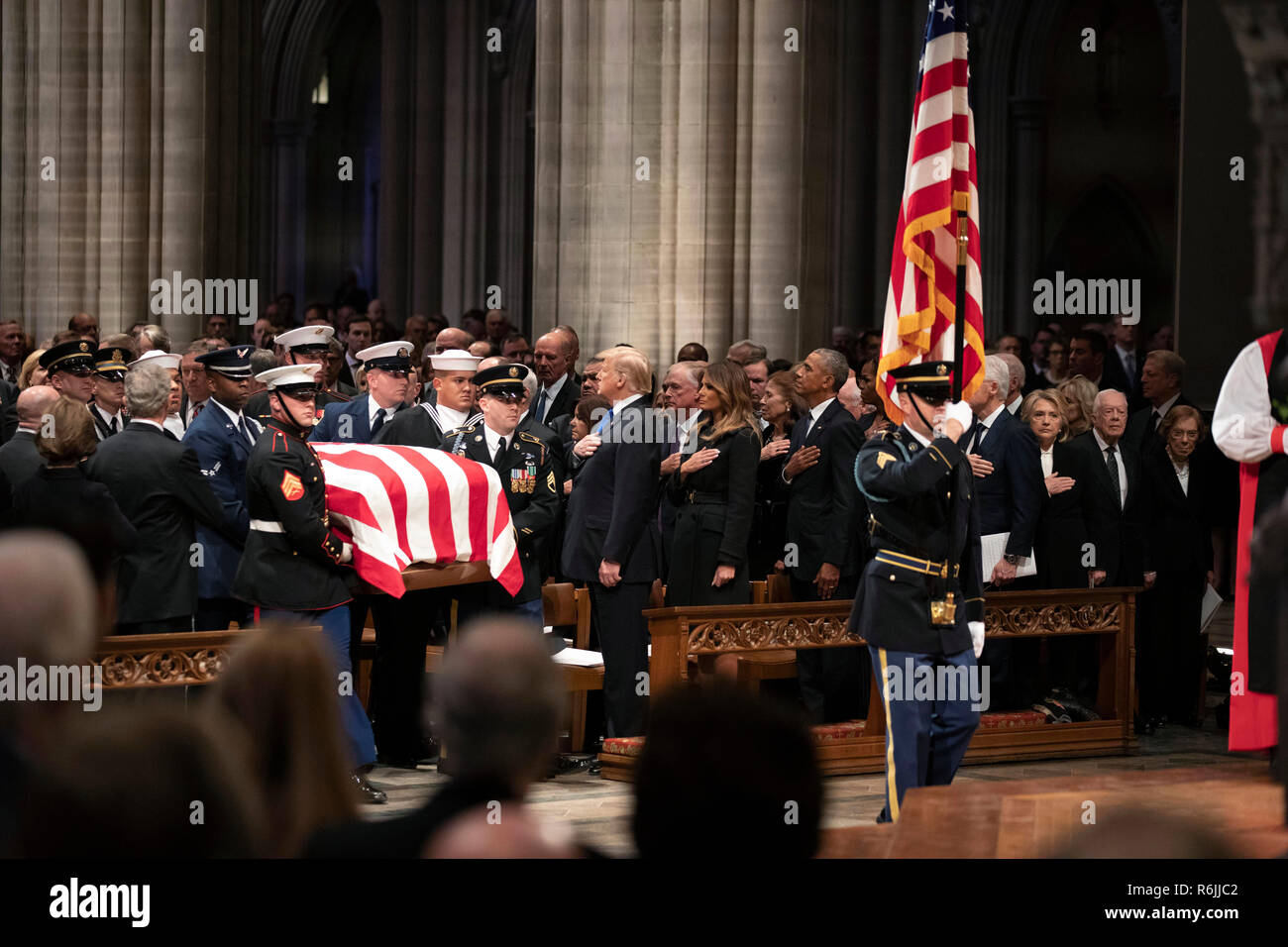 Washington. 5 Dez, 2018. Die Flagge - drapierte Schatulle des ehemaligen Präsidenten George H.W. Bush wird durch eine militärische Ehrengarde Vergangenheit ehemaliger Präsident George W. Bush durchgeführt, linke Seite, Präsident Donald Trump, erste Dame Melania Trump, ehemaliger Präsident Barack Obama, Michelle Obama, der ehemalige Präsident Bill Clinton, der ehemalige Außenministerin Hillary Clinton, der ehemalige Präsident Jimmy Carter, und Rosalynn Carter bei einem Staatsbegräbnis in der National Cathedral, Mittwoch, Dezember 5, 2018, in Washington. Credit: Alex Brandon/Pool über CNP | Verwendung der weltweiten Kredit: dpa/Alamy leben Nachrichten Stockfoto