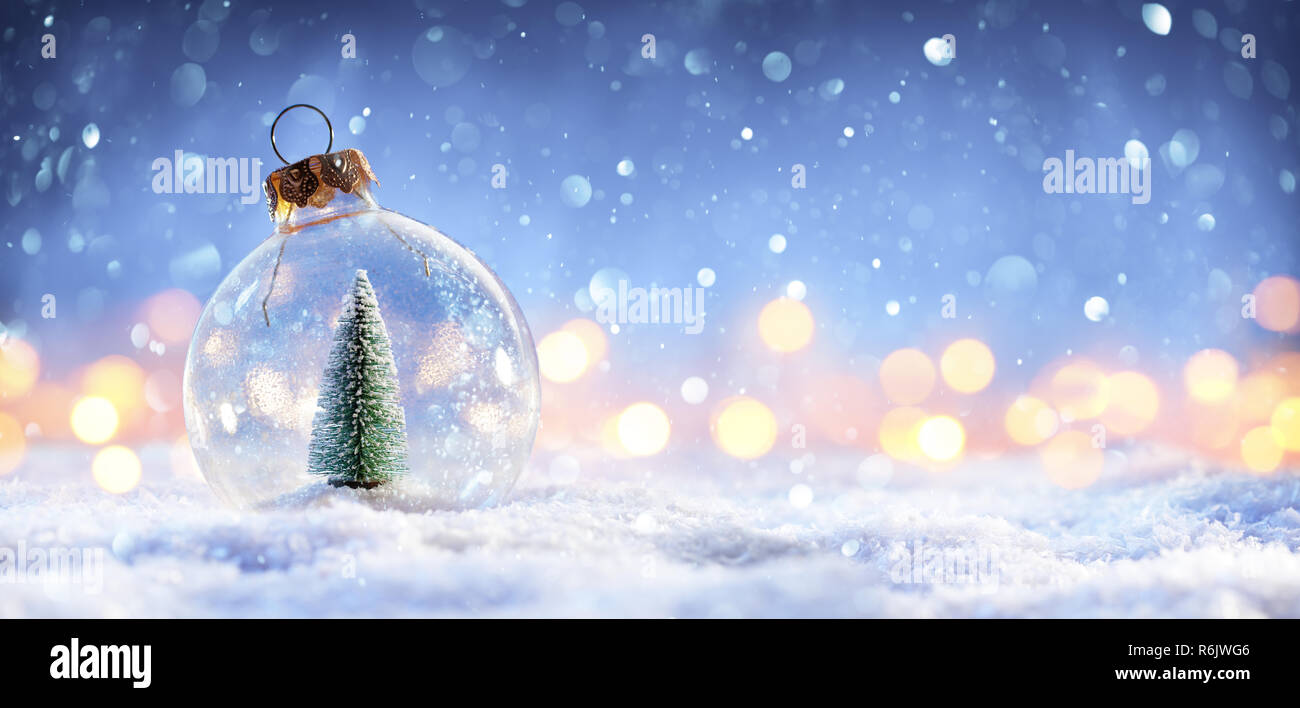 Snow Ball mit Weihnachtsbaum und Lichter auf Winter Hintergrund Stockfoto