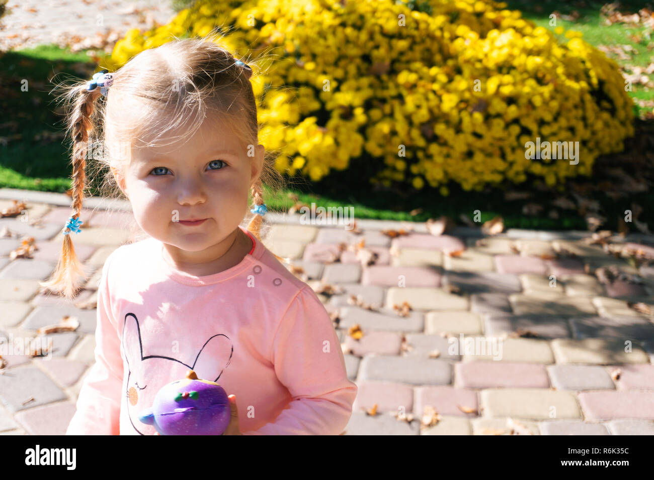 Kleines Mädchen in der Nähe von Pflanzen im Park Stockfoto