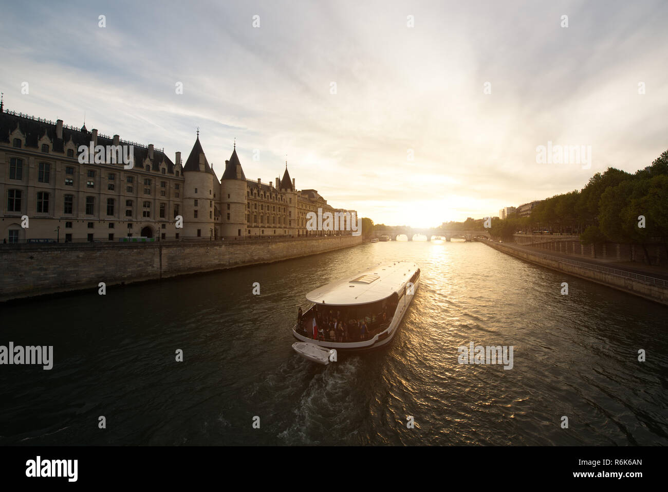 Touristische Bootsfahrt auf der Seine Fluss mit schönen Sonnenuntergang in Paris. Kreuzfahrtschiff Sehenswürdigkeiten entlang des Flusses in Paris, Frankreich. Stockfoto