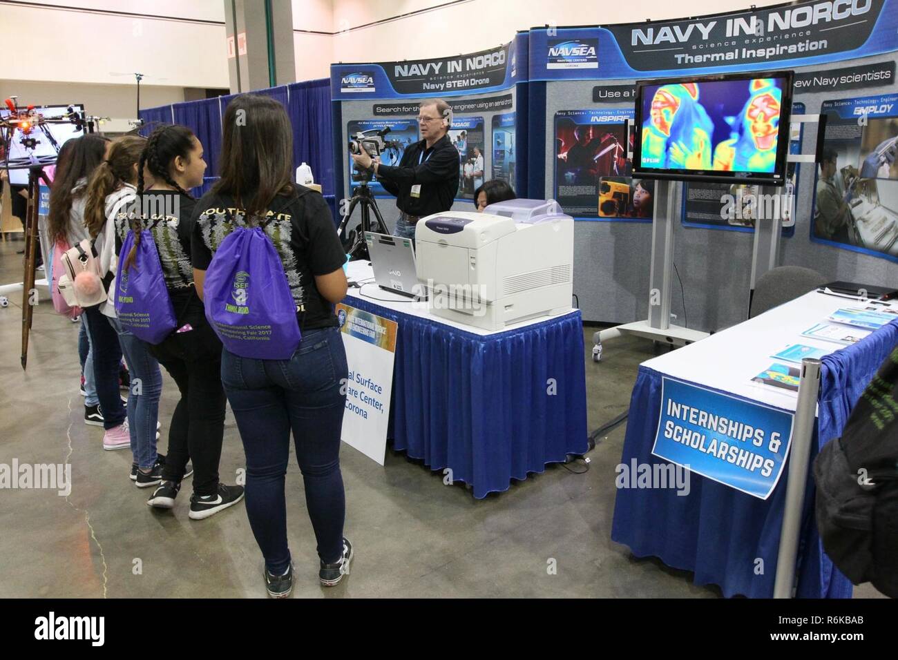 LOS ANGELES (18. Mai 2017) Einen Naval Surface Warfare Center Corona Abteilung Mitarbeiter ein Porträt zeigt den Teilnehmern mit einer vorausschauenden Infrarot (Flir) Kamera, während Intel International Science and Engineering Fair (Isef). NSWC von Corona Beteiligung unterstützt die Strategie der Marine zu inspirieren, begeistern und die nächste Generation von Wissenschaftlern und Ingenieuren zu erziehen. Stockfoto