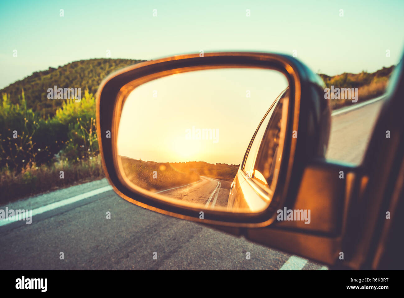 Schönen Sonnenuntergang in Seitenansicht auto Spiegel auf Mountain Road Stockfoto