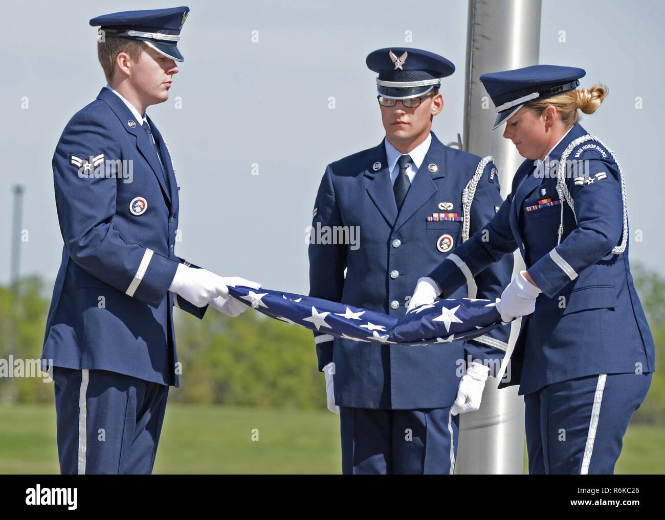 Minot Air Force Base, N.D., Ehrengarde Flieger falten Sie die Flagge während der Nationalen Polizei Woche retreat Zeremonie 19. Mai 2017. Ein retreat Zeremonie ist die tägliche militärische Praxis des Senkens der Flagge. Stockfoto