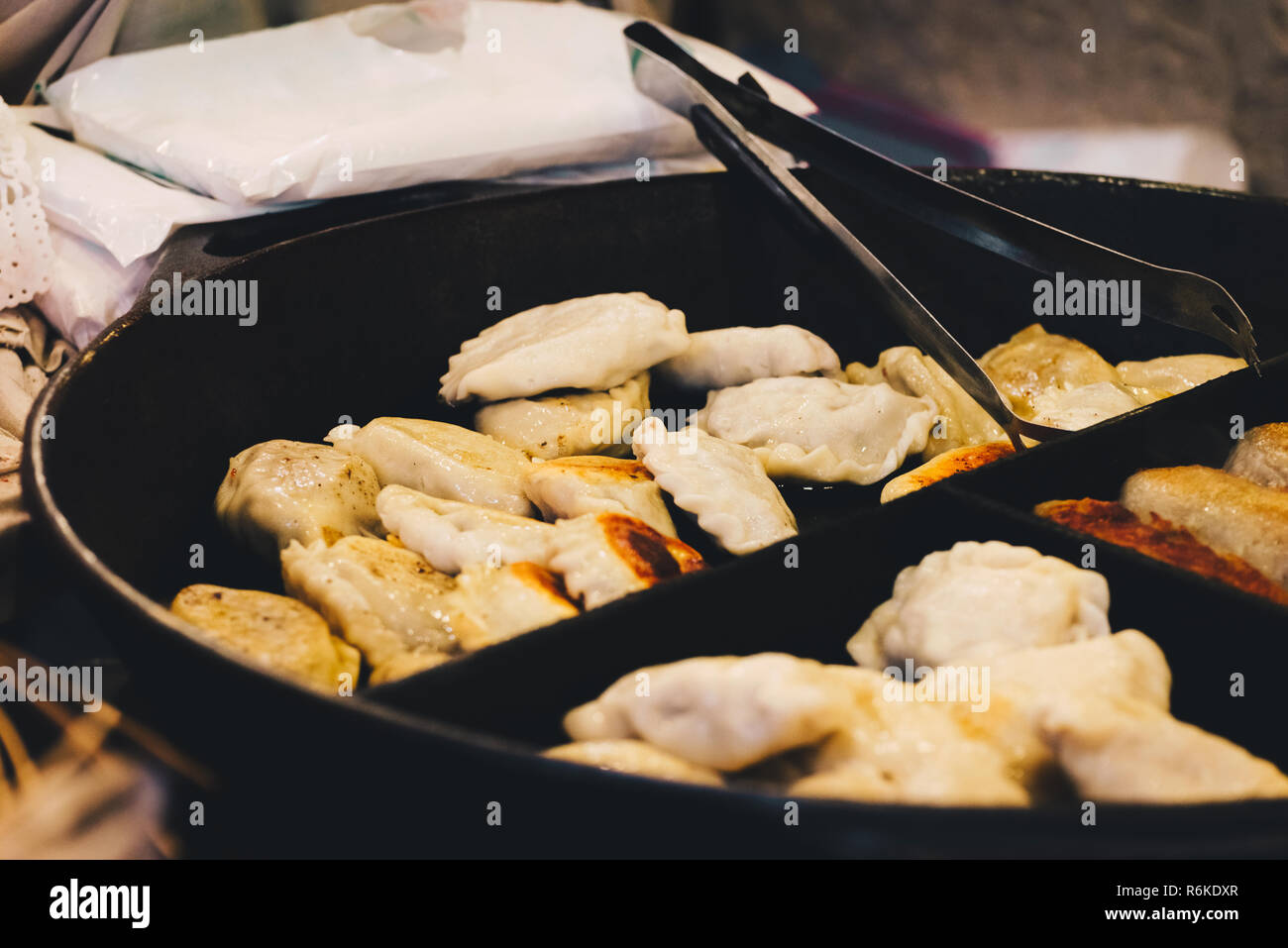 Gebratene Knödel mit Fleisch kochen an der Pan auf der Straße gefüllt. Traditionelle Weihnachten Piroggen. Straße national food. Stockfoto