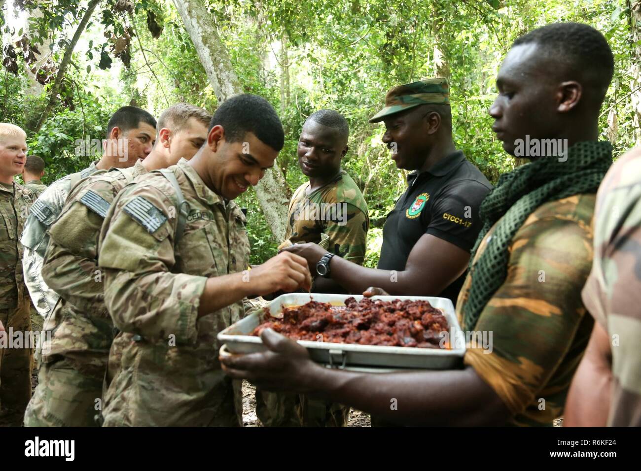 Us-Soldaten auf die 1 Battalion, 506Th Infantry Regiment, 1st Brigade Combat Team, 101St Airborne Infanterie Division, Schlange Python während ein Überleben im Dschungel Kriegsführung Schule vorbereitet auf Achiase Militärbasis in Akim Oda, Ghana am 19. Mai 2017 zu essen. Die Jungle Warfare School ist eine Reihe von situativen Übungen entwickelt, die Teilnehmer in die Train-Aufstand und die innere Sicherheit. Stockfoto