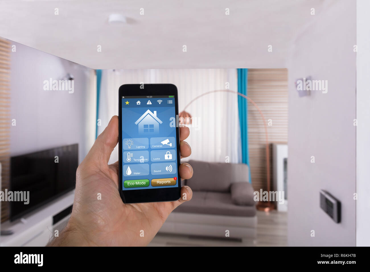 Die menschliche Hand mit Smart Home System auf dem Smartphone Stockfoto