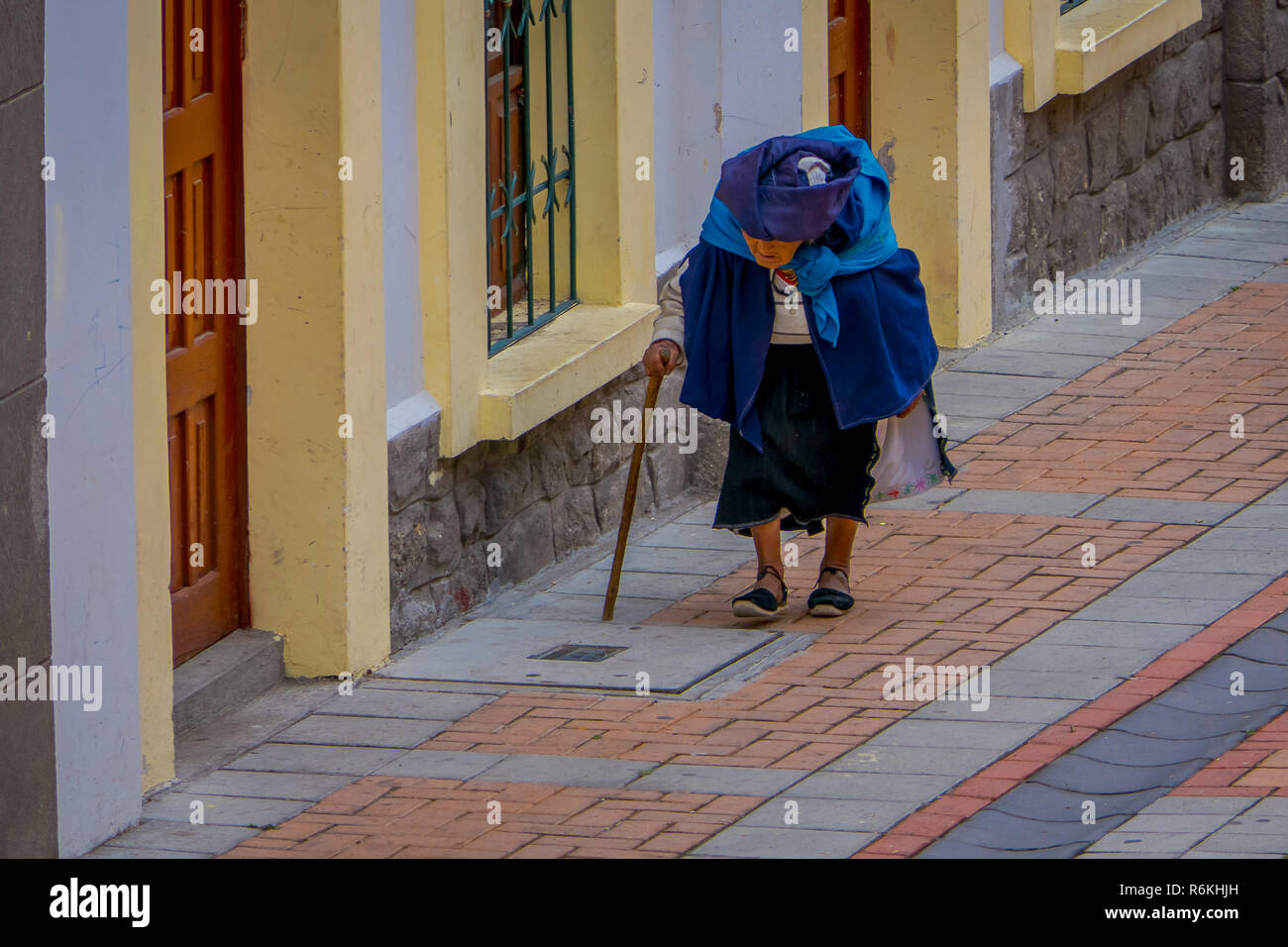 COTACACHI, Ecuador, November 06, 2018: die alten indigenen Frau Wandern in den Straßen der Stadt Cotacachi mit einem Wanderstock und schwere Tasche in h führen Stockfoto