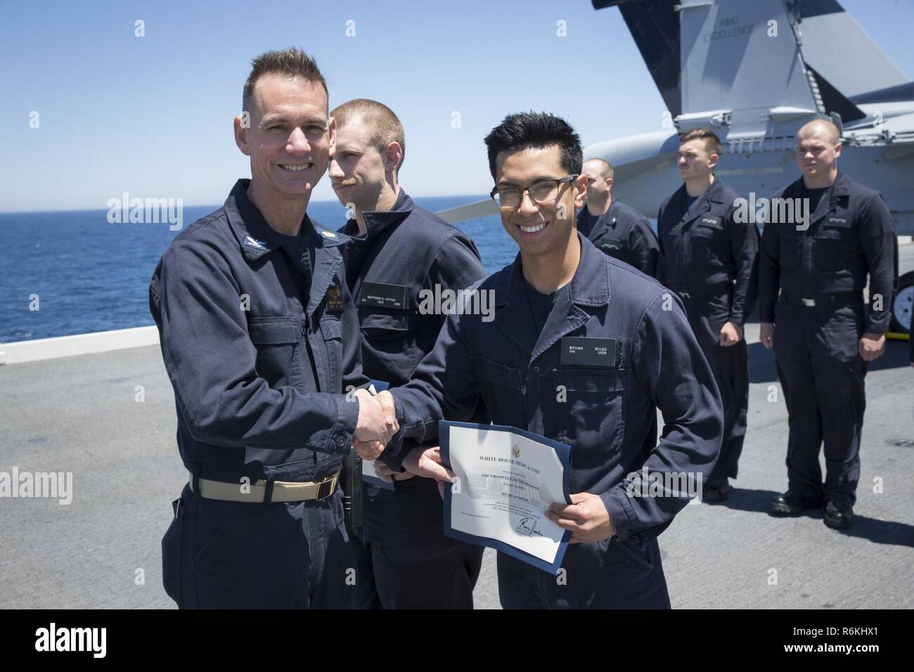 Atlantischer Ozean (26. Mai 2017) - Hospitalman Bryan Rivas, von Fort Meyers, Florida, zu Pre-Commissioning Unit Gerald R. Ford's (CVN 78) zahnmedizinische Abteilung zugewiesen, erhält einen Weißen Haus medizinische Einheit Anerkennung Zertifikat bei einer Preisverleihung im Viertel Zeremonie auf dem Schiff Flight Deck. Die Zukunft USS Gerald R. Ford (CVN 78) - der erste neue US-Flugzeugträger Design in 40 Jahren mehrere Tage verbrachte die Durchführung von Abnahmetests, einen umfassenden Test von vielen der wichtigsten Systeme des Schiffes und Technologien. Abnahmetests ist ein wichtiger Meilenstein auf dem Weg zur Inbetriebnahme. Stockfoto