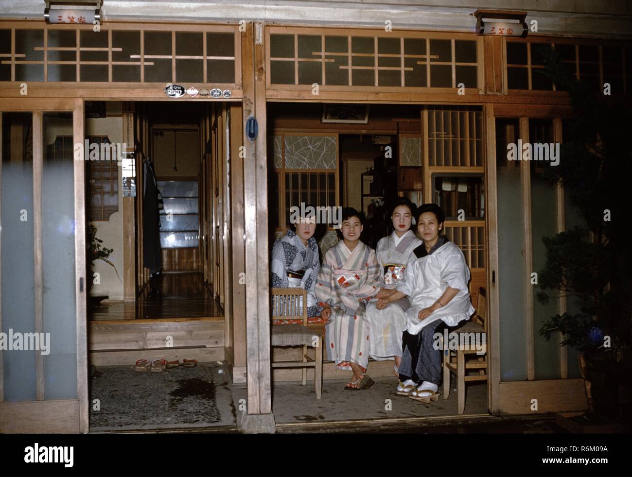 Vier Frauen tragen bunte Kimonos sitzen in einem traditionellen japanischen Minka Haus mit Papier und Holz Wände, der Nachkriegszeit in Japan, 1955. () Stockfoto