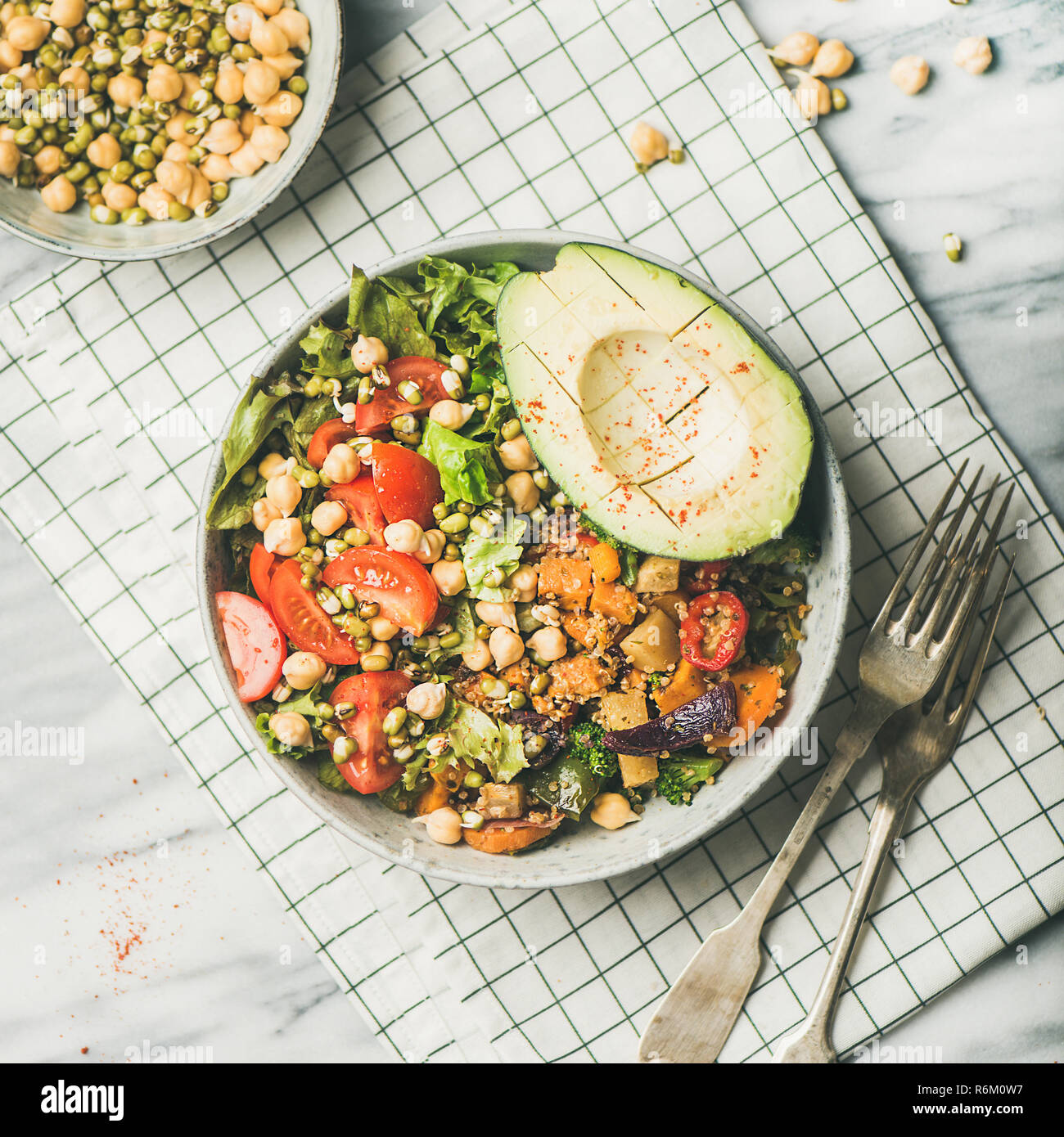 Vegan Schüssel mit Avocado, Getreide, Bohnen und Gemüse, Marmor Hintergrund Stockfoto