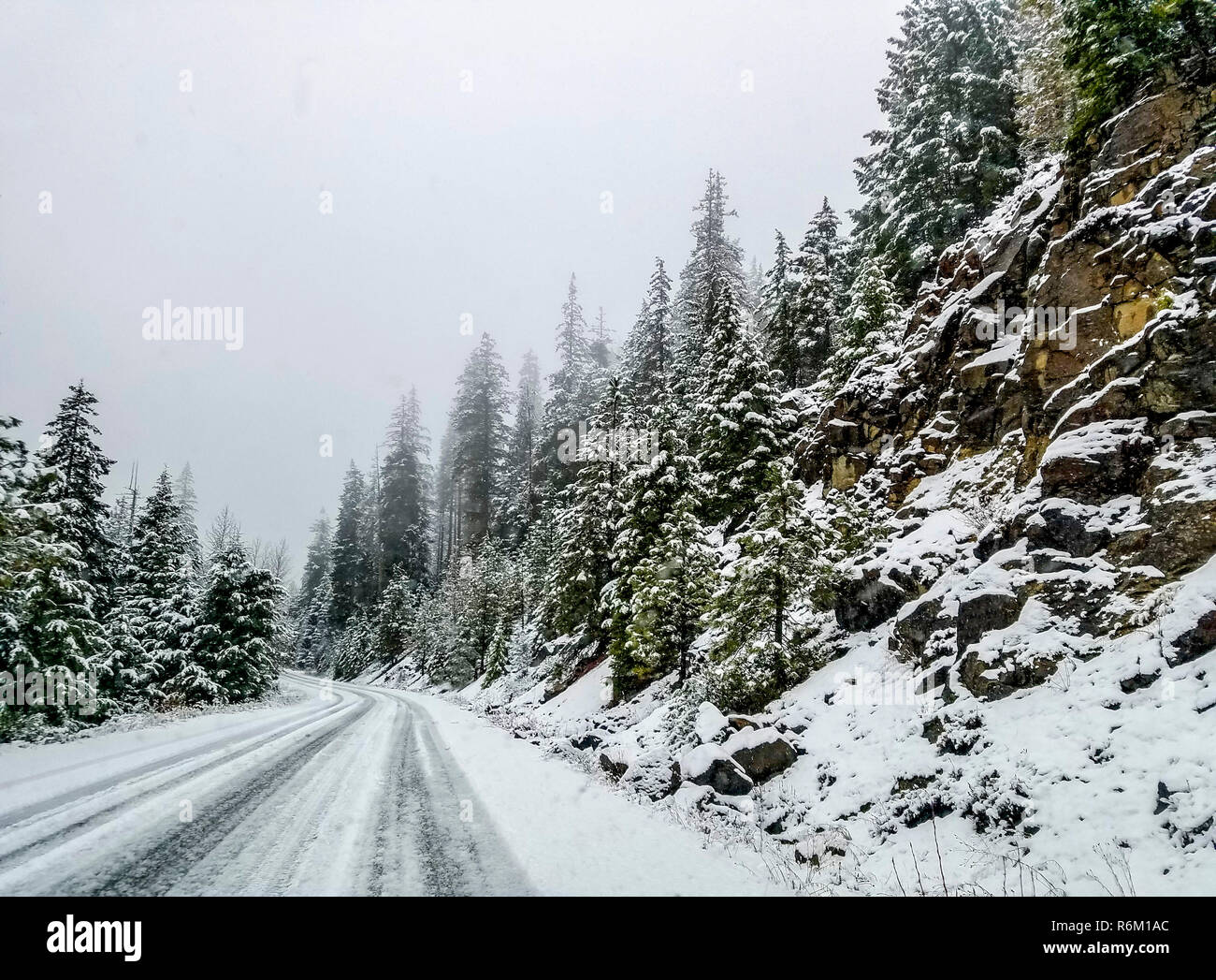 Icicle Creek im Winter mit leicht fallenden Schnee. Stockfoto