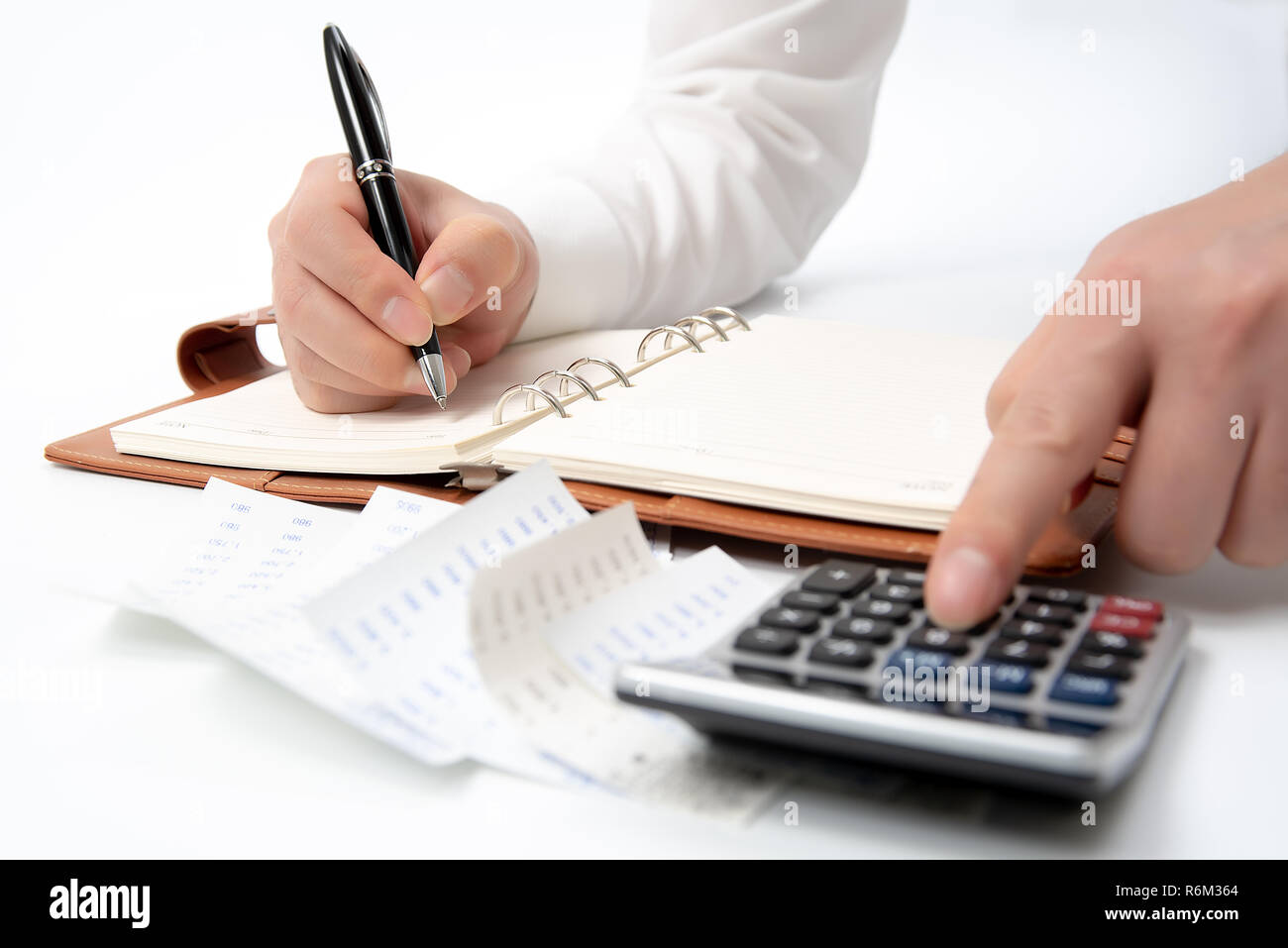 Hände der Unternehmer schriftlich eine Quittung auf einem Notebook, close-up. Stockfoto