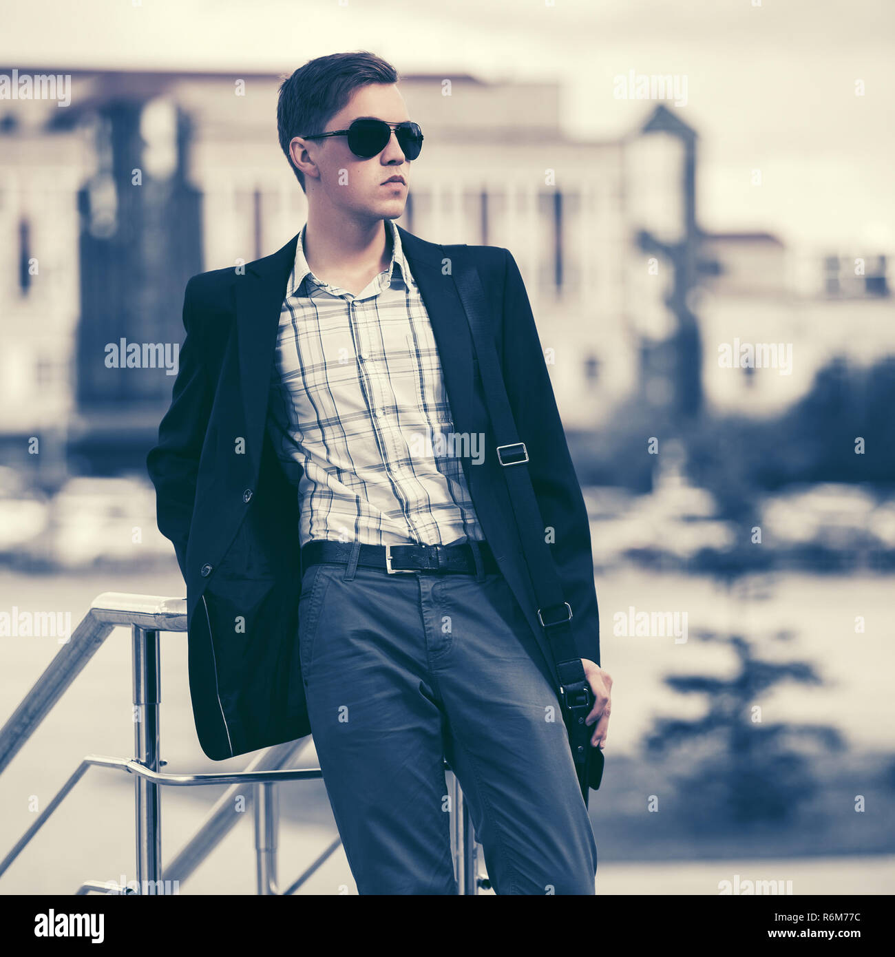 Junge gut aussehender Geschäftsmann in Sonnenbrille im city street Stilvolle männliches Modell in Schwarz Blazer Stockfoto
